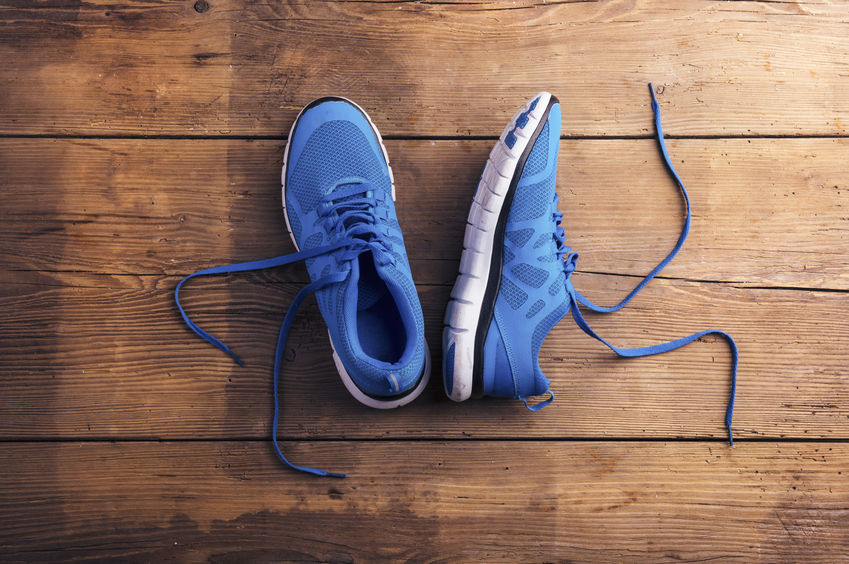 38905988 - pair of blue running shoes laid on a wooden floor background